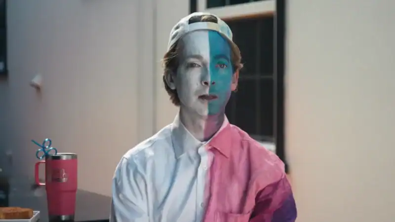 man wearing a backwards baseball cap with blue and white face paint on.