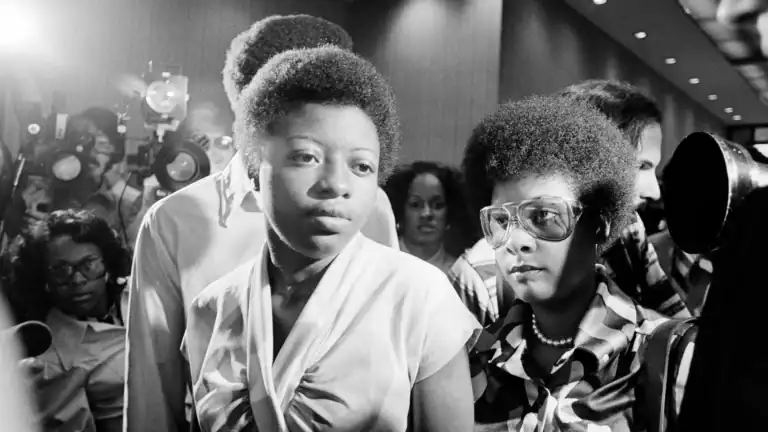 Group of young African American women at a community event, engaging in conversation and listening attentively.