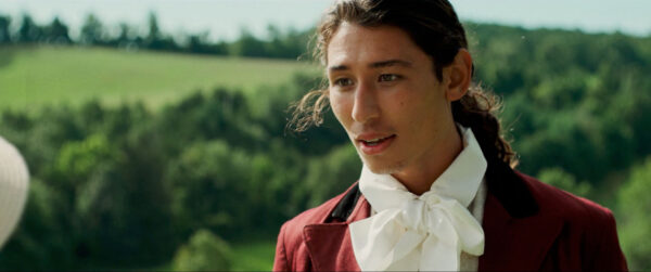 A person with long dark hair appears in 18th-century attire, featuring a red coat and a white cravat, with a peaceful countryside in the background.