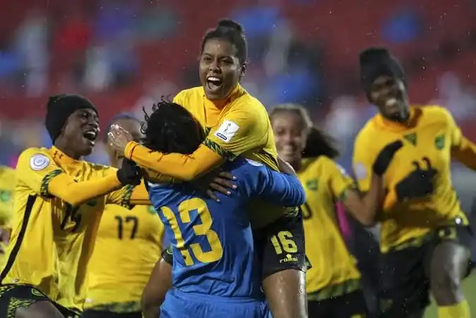 Women soccer players celebrating victory on the field after a match, wearing yellow and blue uniforms, with joyful expressions and team camaraderie.