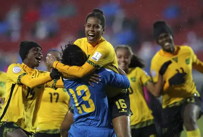 Women soccer players celebrating victory on the field after a match, wearing yellow and blue uniforms, with joyful expressions and team camaraderie.