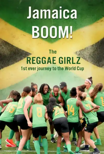 Women soccer players group up in a circle with Jamaican flag behind them