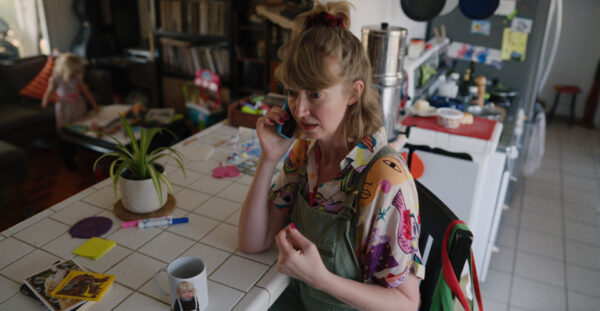 a woman, with a concerned expression, talking on the phone.