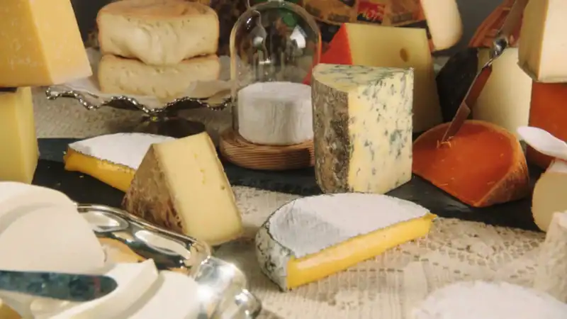 A close up of a table decorated with different types of cheeses.
